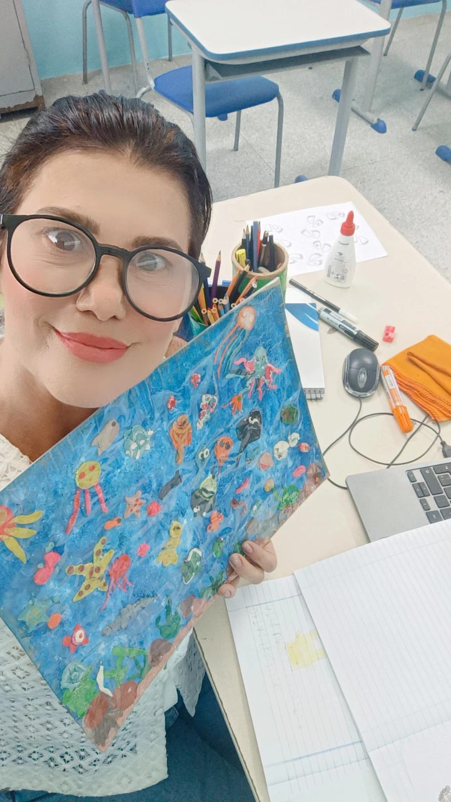 Professora Paula mostra o "aquário interativo", produzido com massinha pelos alunos, a partir da prototipação do projeto vencedor do Prêmio. Crédito: Divulgação